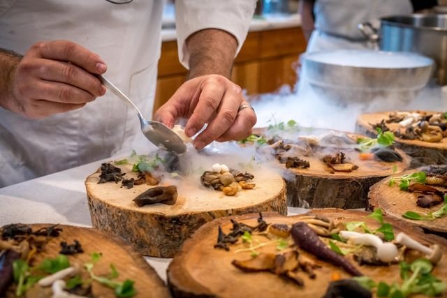 A chef plating dishes at the pass